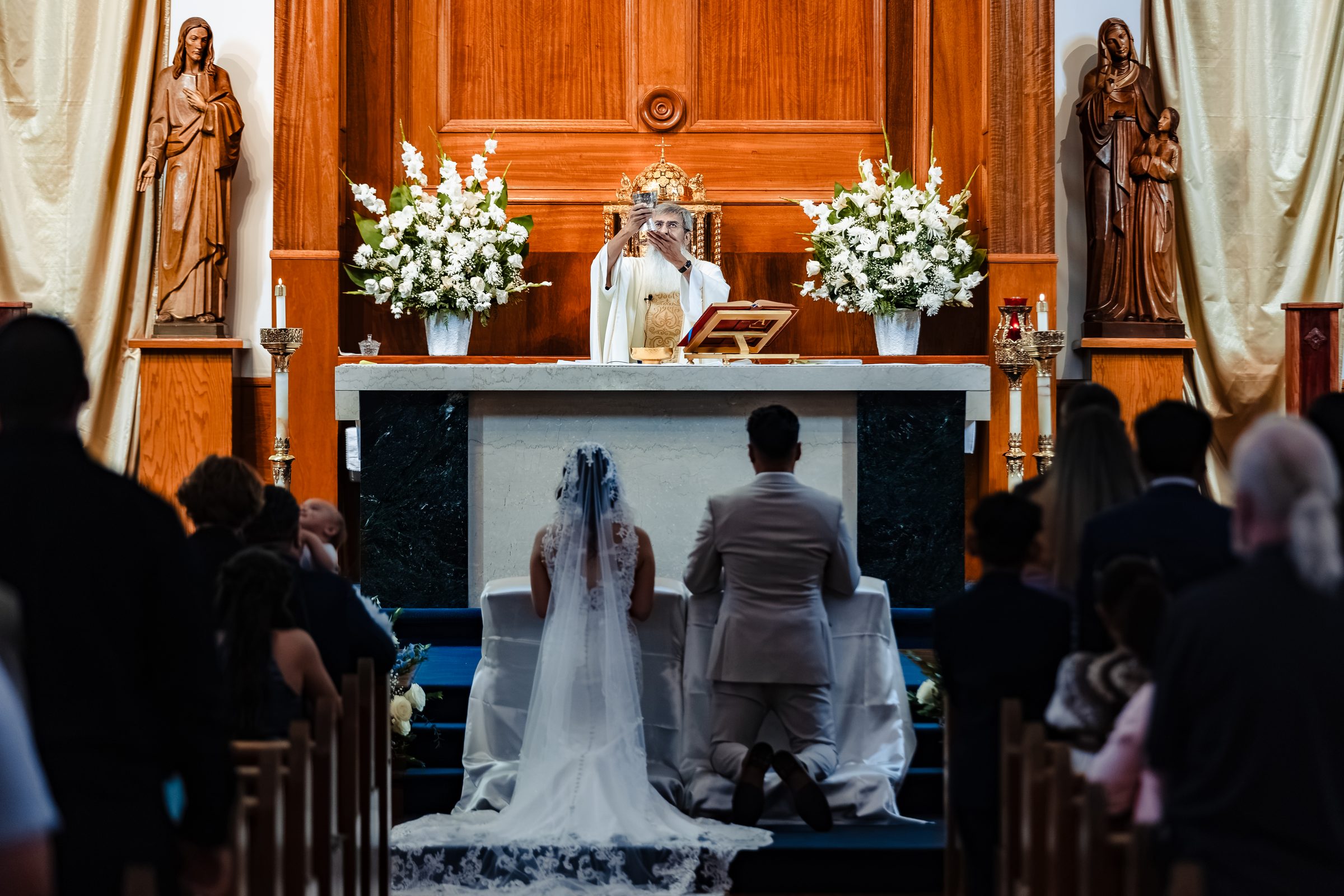 The couple kneeling before the altar during the consecration