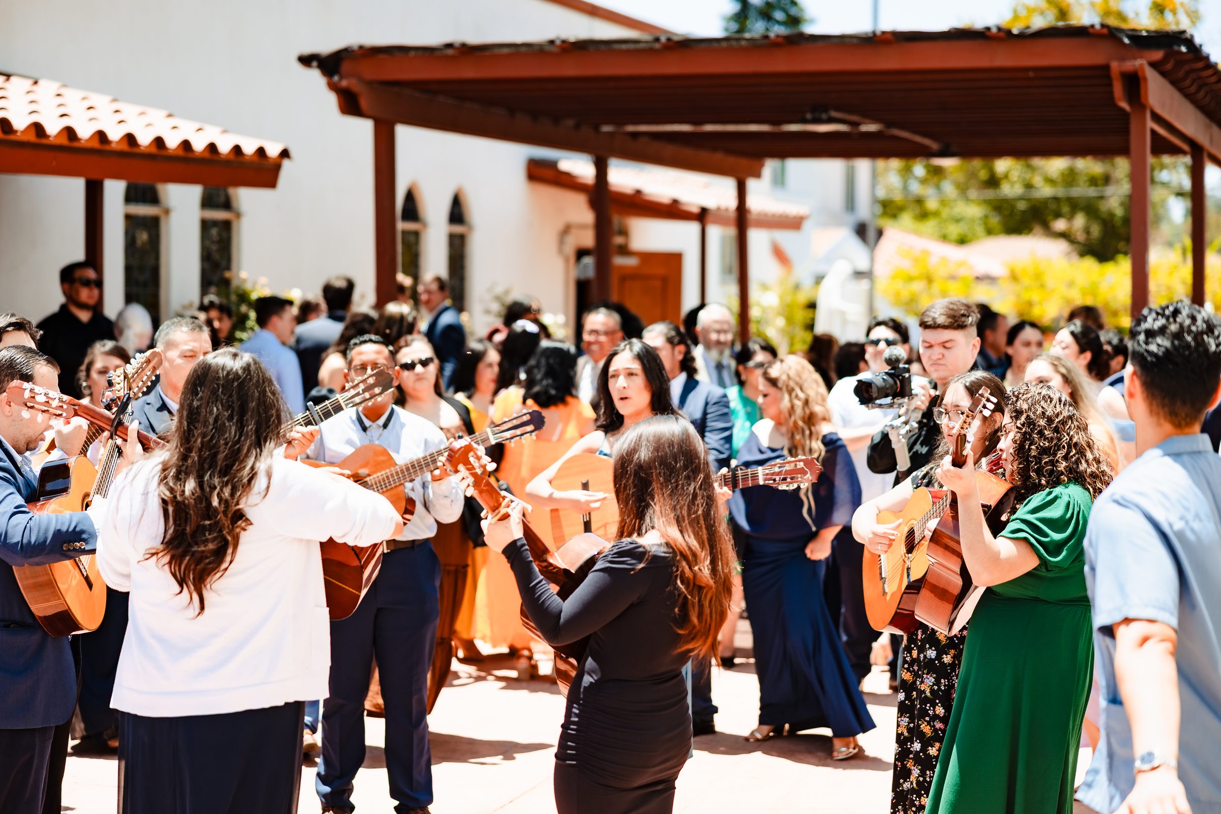 Family and friends celebrating with mariachi on the church patio