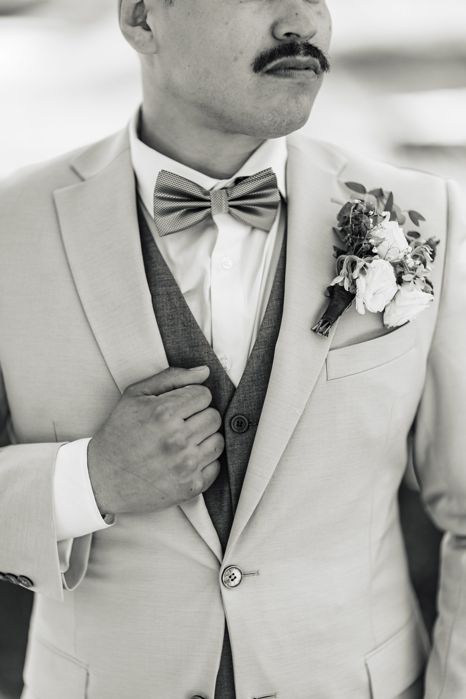 Black and white detail of the groom's suit and boutonniere