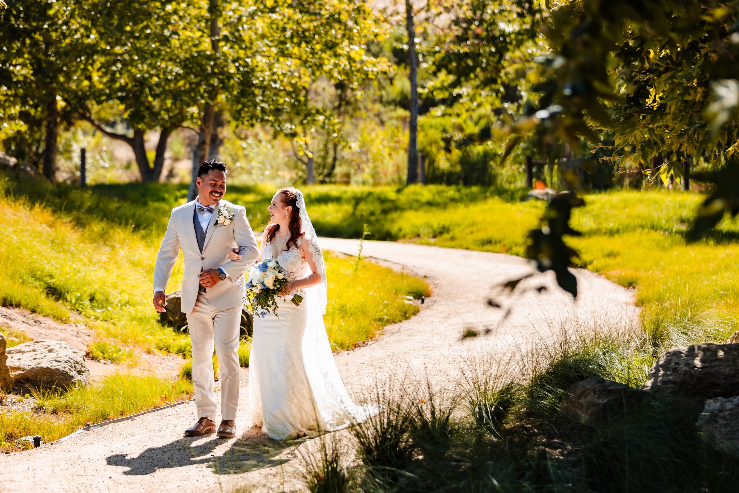 The couple walking hand in hand through the greenery