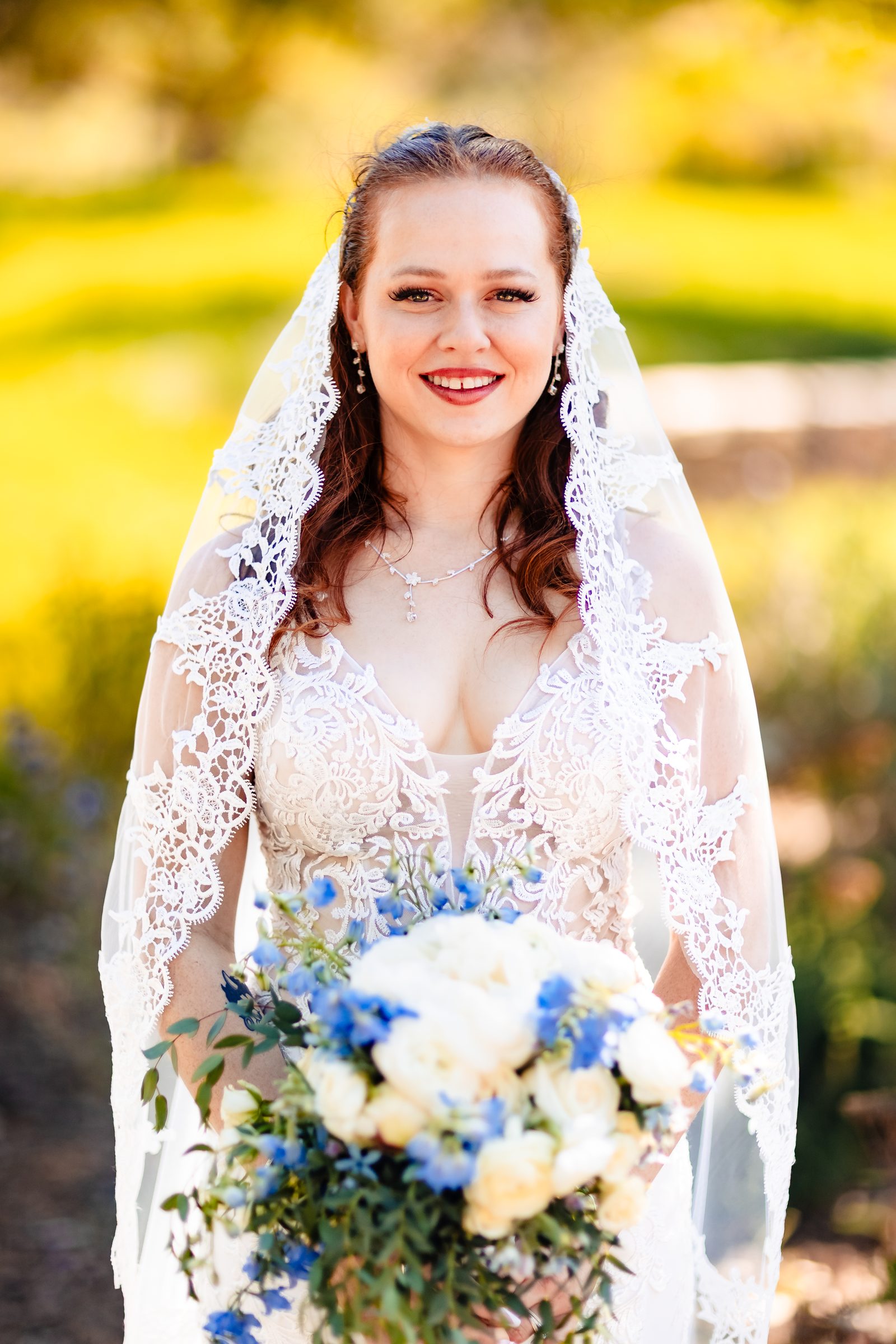 Bridal portrait with blue and white bouquet and lace veil