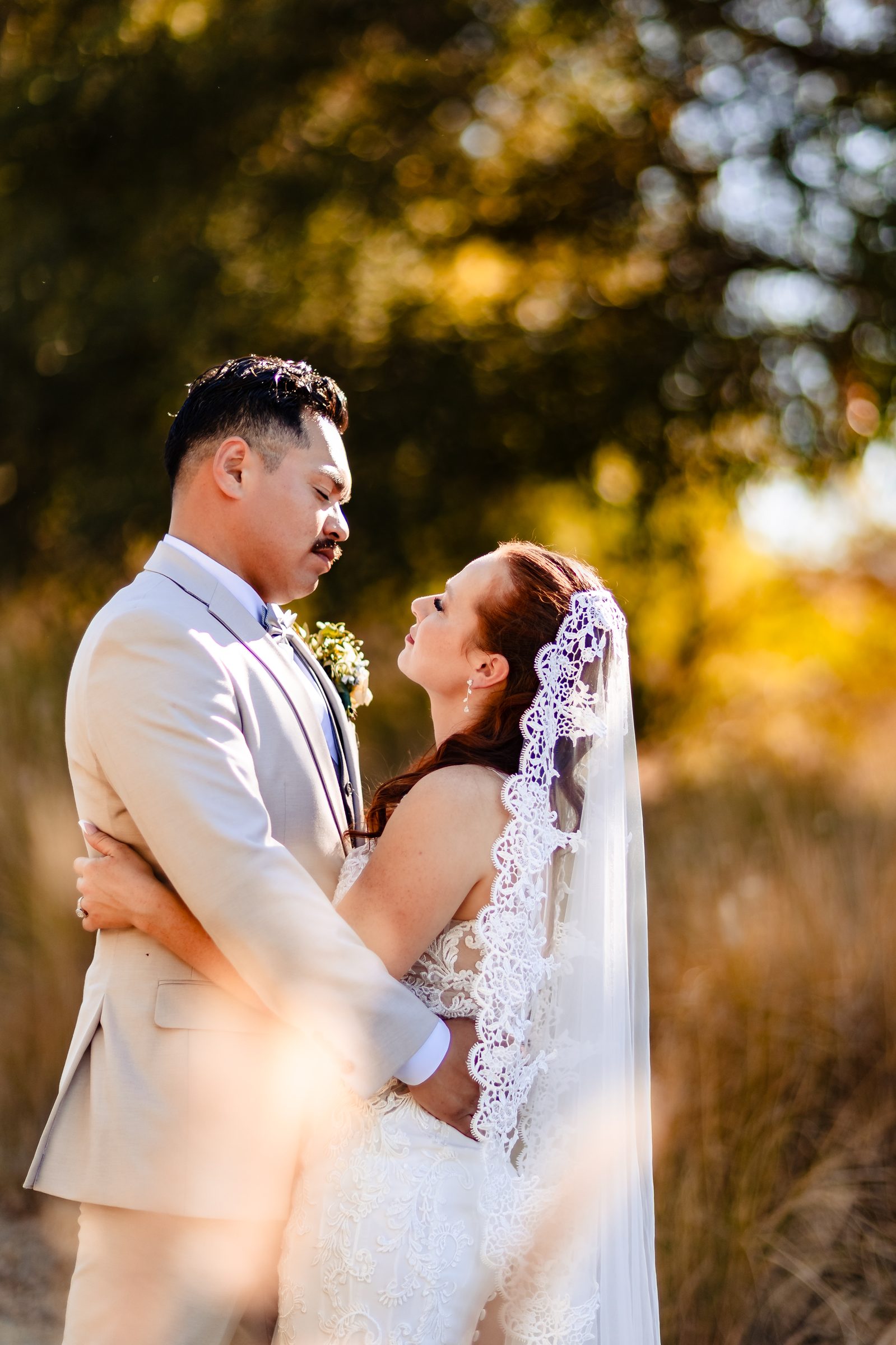 Isaac and Brittany embracing in golden grasses at Shady Oaks Canyon