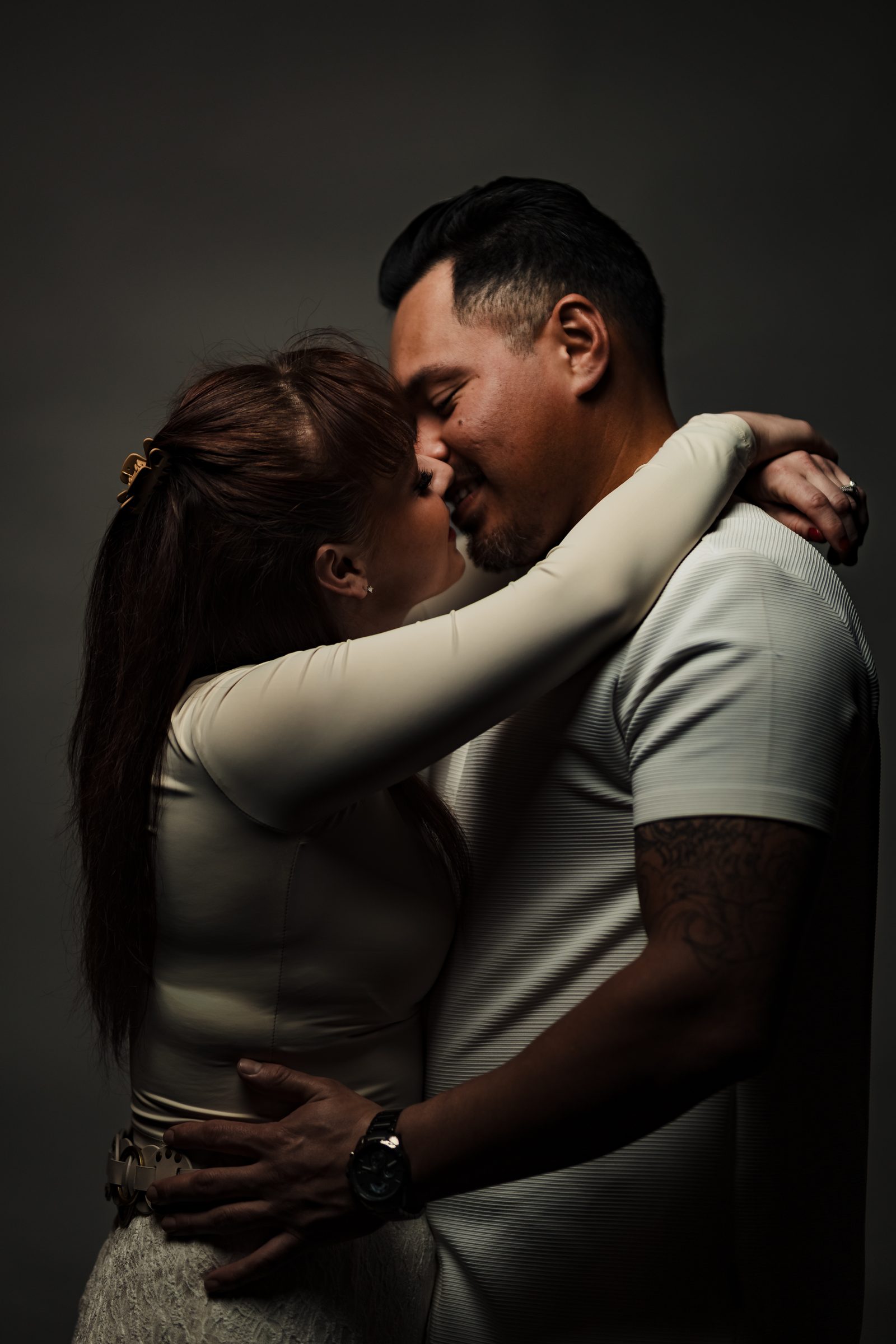 A kiss in a single-light studio engagement portrait