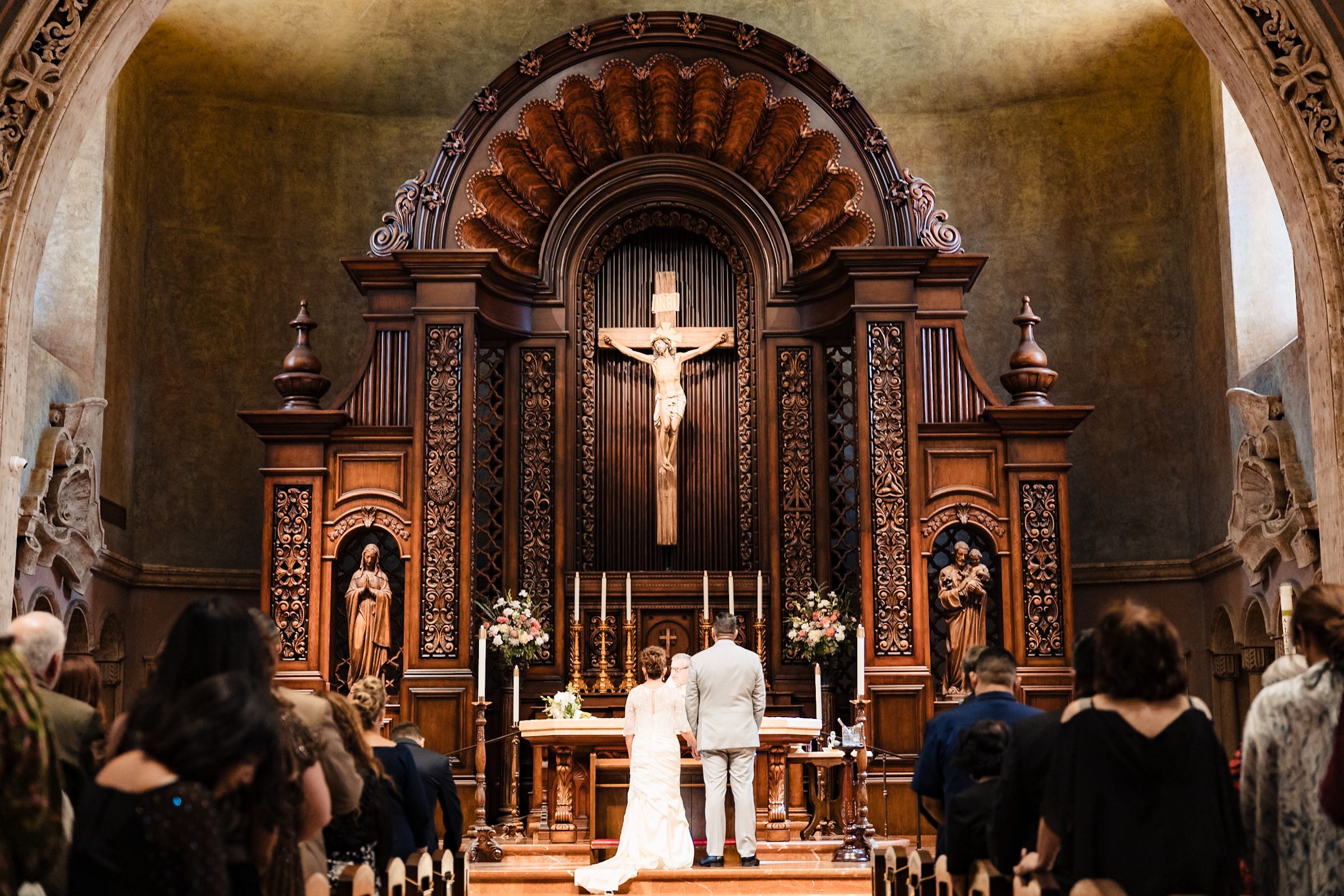 Joe and Victoria before the carved walnut reredos and crucifix of St. Charles Borromeo