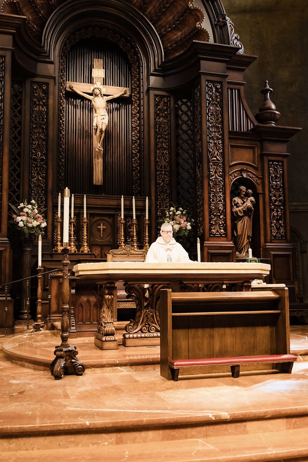 The priest at the altar beneath the crucifix during the Nuptial Mass