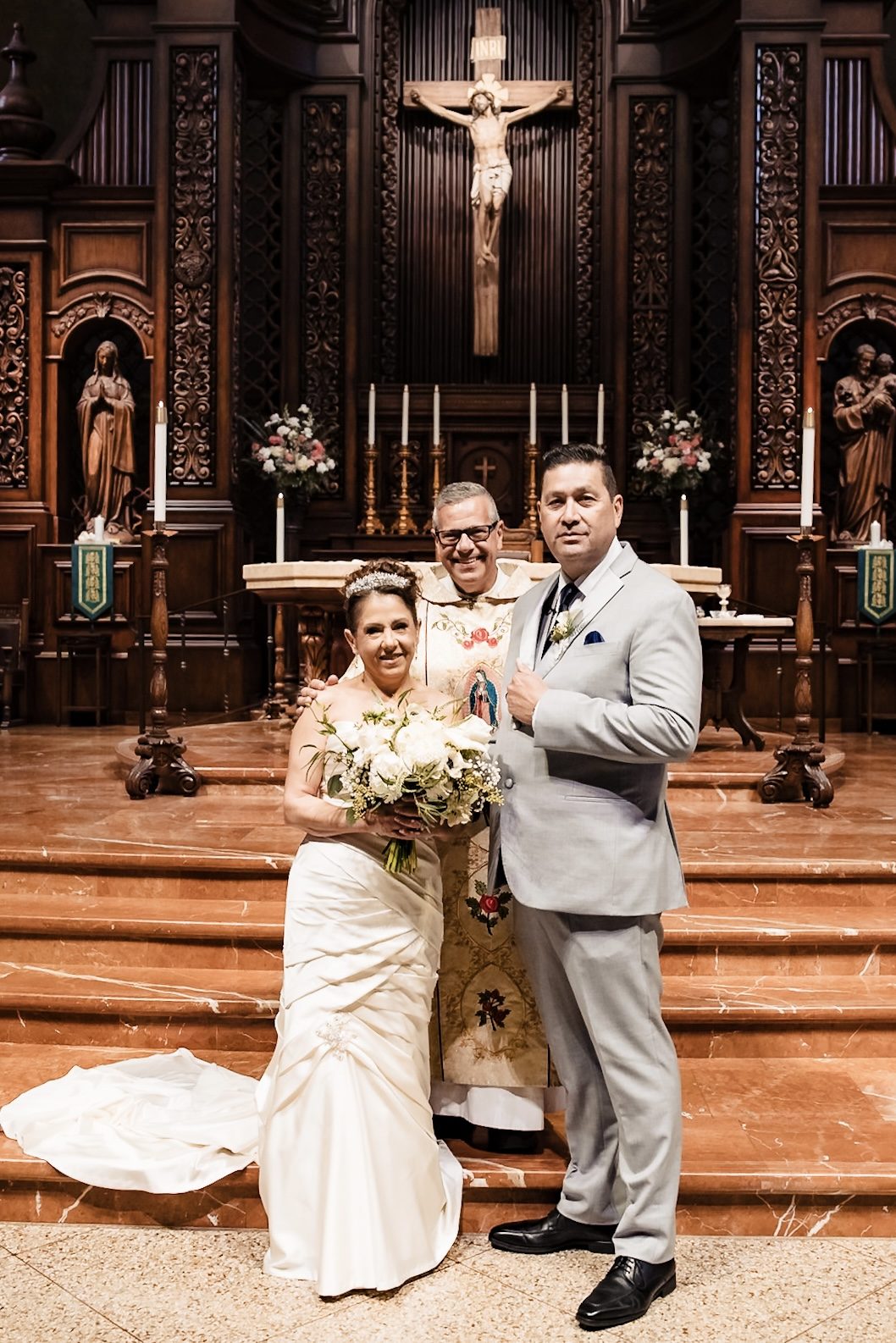 Joe and Victoria with their priest at the foot of the altar