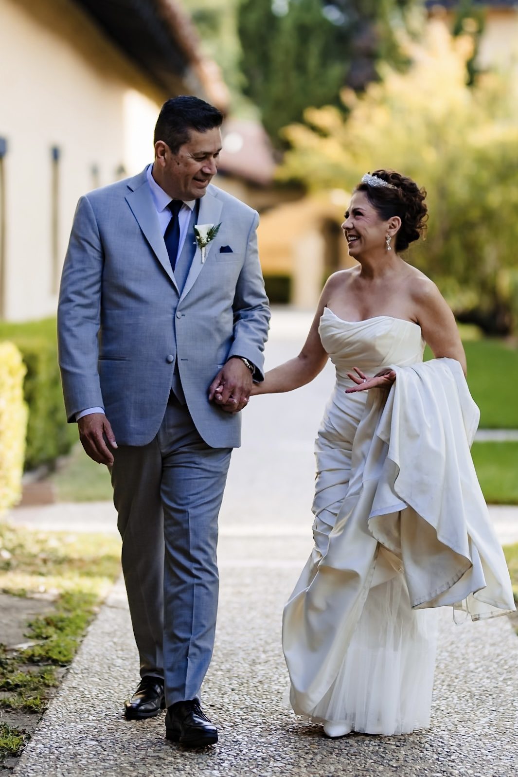 Victoria laughing as they walk hand in hand through the mission grounds