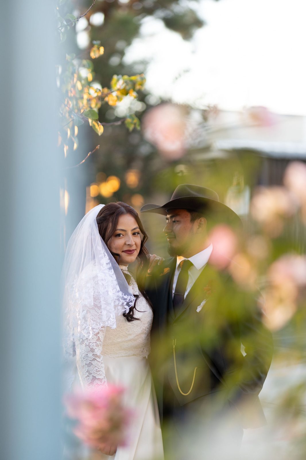 Golden hour wedding portrait of Manny and Lauren framed through spring blooms in Valley Glen