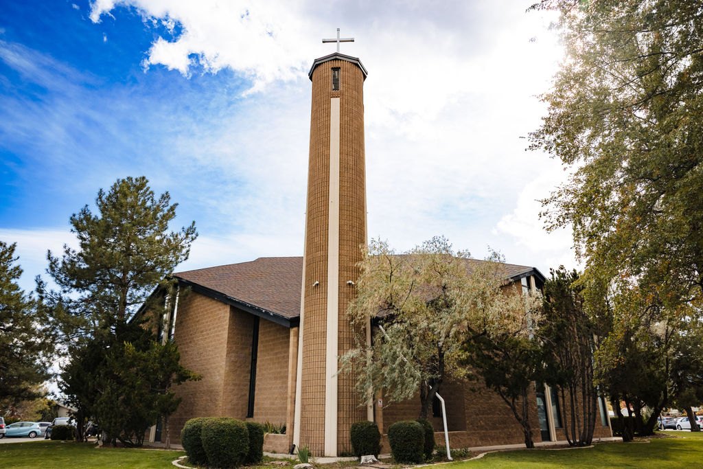 The bell tower of St. Albert the Great against a blue Reno sky