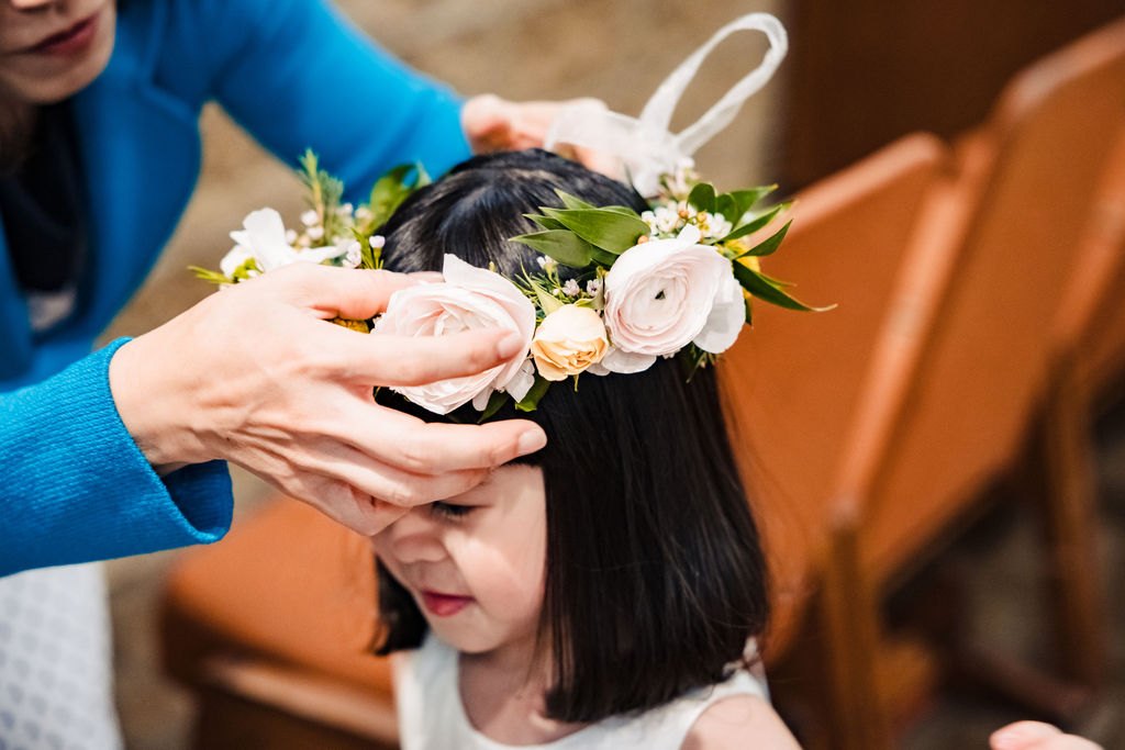 A flower crown placed on a flower girl's head