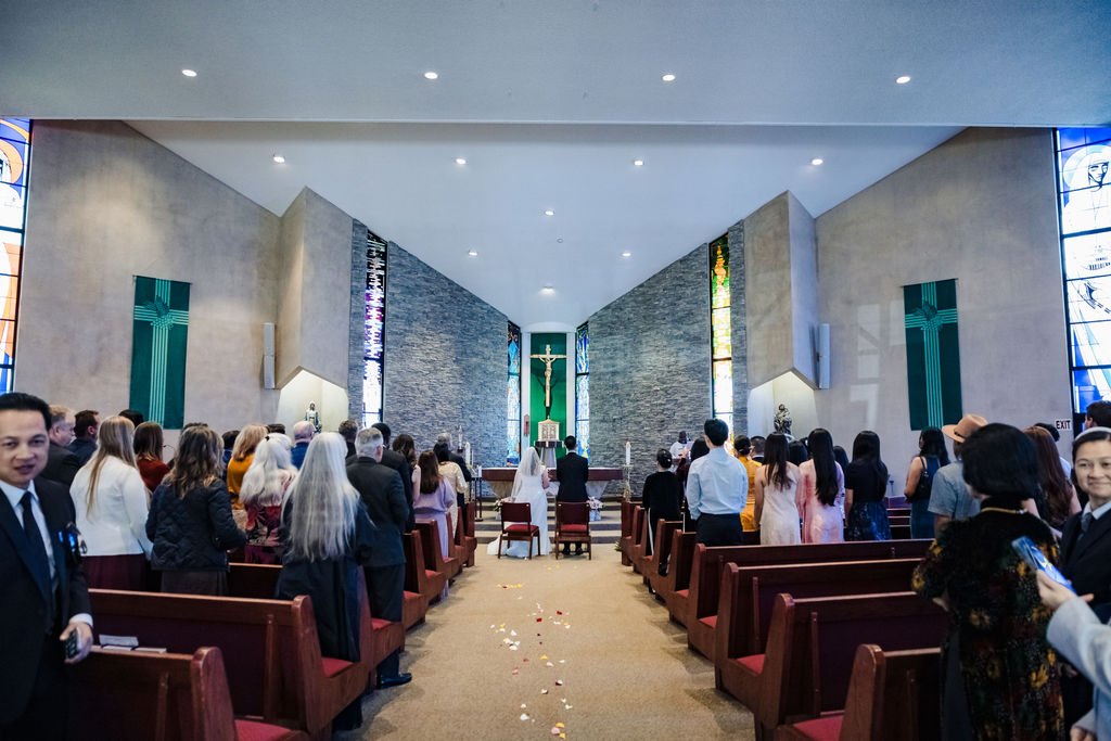 The full church from the back as the bride reaches the altar