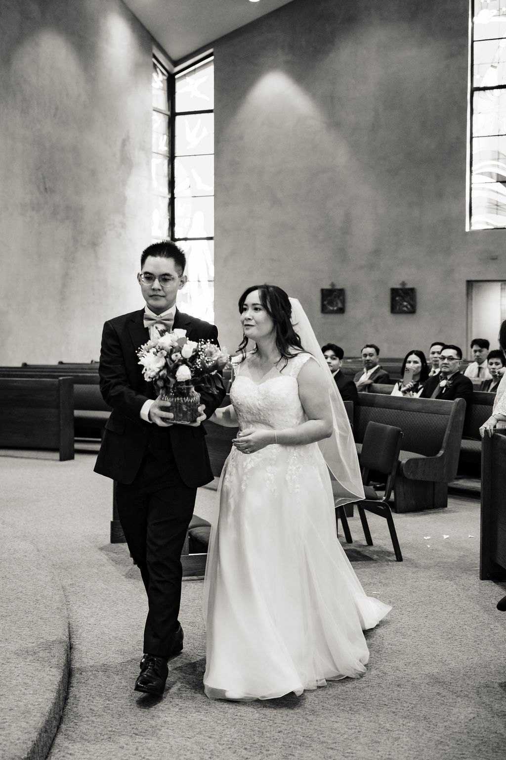 Black and white of Vincent and Ginger walking down the aisle as husband and wife