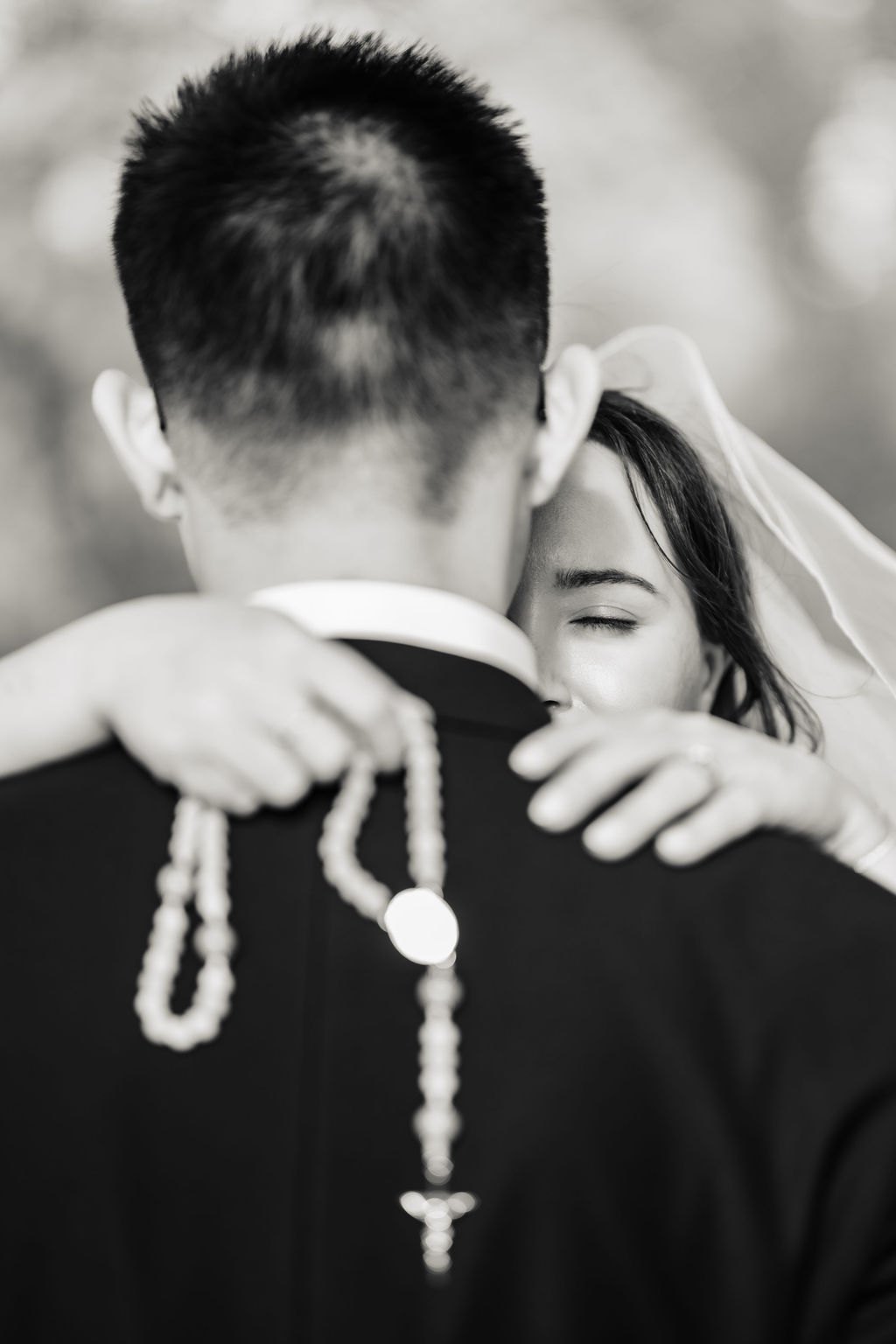Ginger's arms around Vincent's neck holding a white rosary