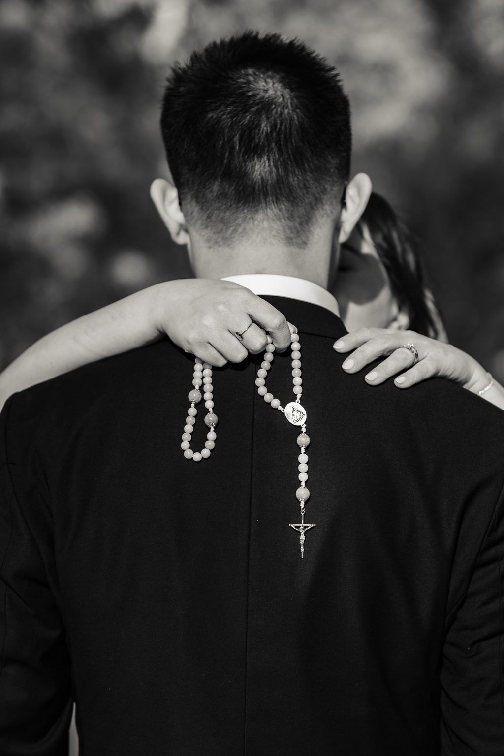 The white rosary hanging down Vincent's back