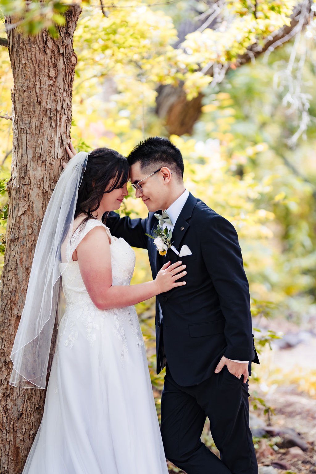 Forehead to forehead beneath an autumn tree