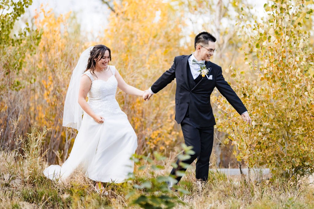 Running hand in hand through golden autumn brush